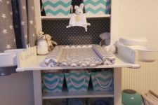 14 a comfy changing table with fabric crates to store diapers and other things