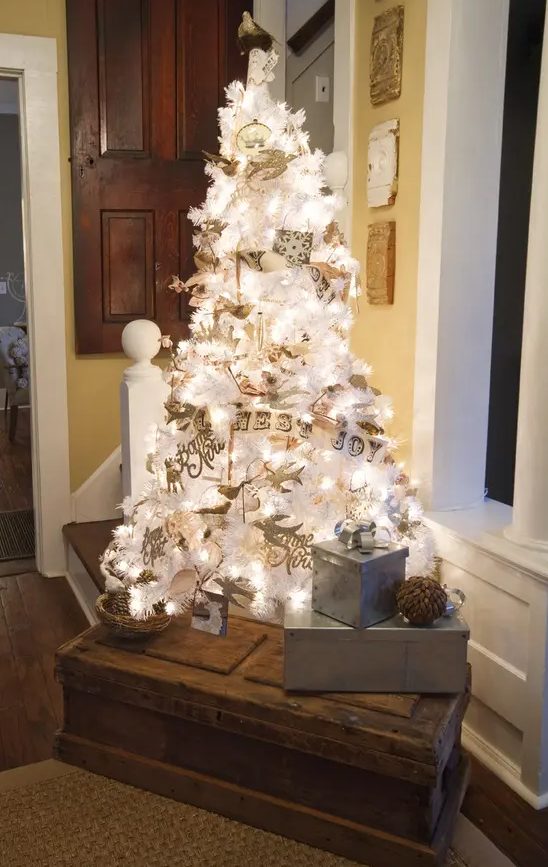 a lovely white vintage Christmas tree with lights and silver and white Christmas ornaments plus banners and calligraphy is wow
