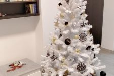 a modern white Christmas tree with gold and black ornaments is a catchy and bold modern solution
