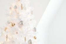 a pure white Christmas tree with lights, silver, gold and pearly ornaments and a pretty shiny snowflake tree topper