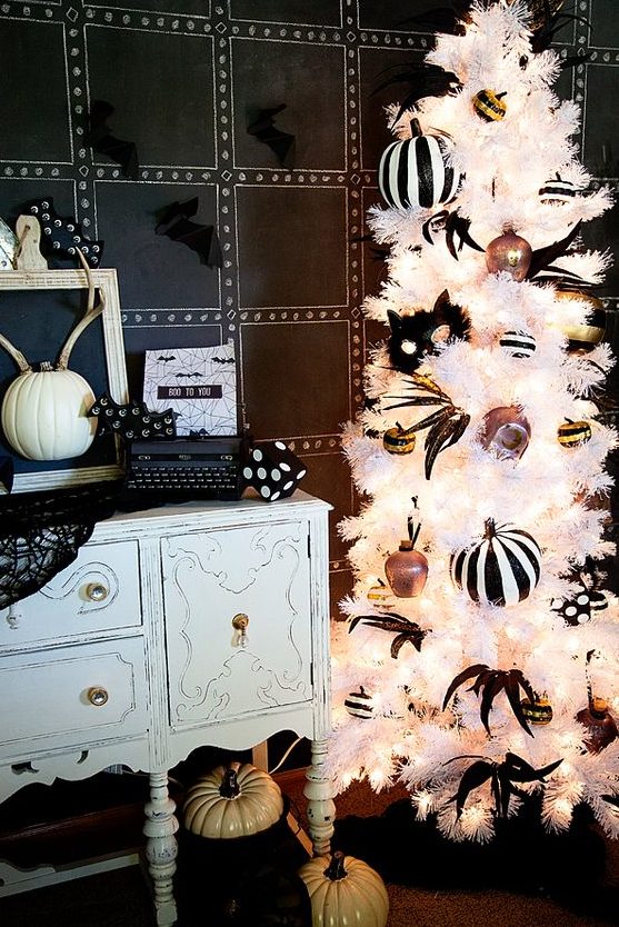 a refined white Halloween tree with striped pumpkins, feathers, ornaments and lights is fantastic
