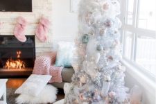 a white Christmas tree styled with pastel green, pink and silver ornaments and with gifts packed in matching boxes