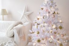 a white Christmas tree with blush, white and gold ornaments, hearts, stars and baubles and lights
