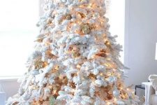 a white Christmas tree with lights and pinecones plus a star tree topper is a fantastic idea for a winter wonderland space