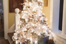 a white Christmas tree with lights decorated with vintage-inspired ornaments and paper buntings is very cool