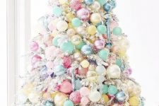 a white Christmas tree with pastel blue, yellow, pink, blush and other ornaments fully covering the tree and making it look fantastic