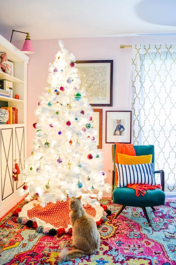 a white Christmas tree with super colorful ornaments looks contrasting and bold