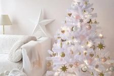 a white lit up Christmas tree with pink, gold and white ornaments, a large star is ideal for this glam white space