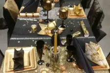 04 a black and shiny metallic tablescape with lots of ornaments, stars, metallic chargers looks very bold and glam