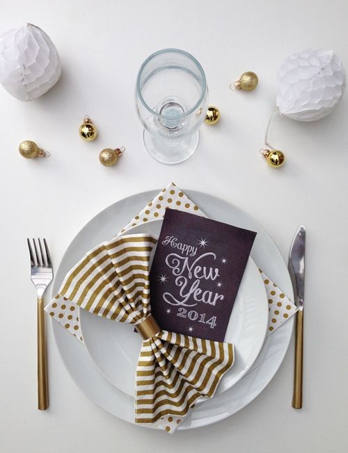 a simple place setting with touches of gold, a chalkboard card and tiny shiny ornaments