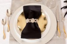 07 a gold plate, a silver glitter place mat and a black napkin with an embellished ring