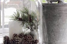 09 a large cloche with a pillar candle, pinecones and pine branches in a vase