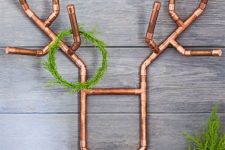 11 a creative deer head of copper pipes with a small green wreath for a modern space