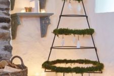 11 a wrought iron Christmas tree decorated with greenery and white paper ornaments
