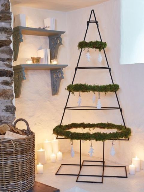 a wrought iron Christmas tree decorated with greenery and white paper ornaments