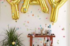 12 a step bar cart with large gold letter balloons over it – you won’t need more decor