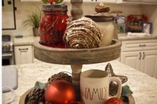 12 a two-tier tray with ornaments, pinecones, mason jars with berries and mugs