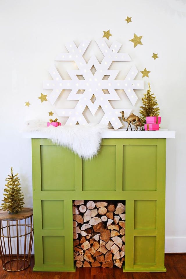an oversized snowflake sign on the mantel is a chic and glam idea