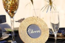 14 a navy, black and gold table setting with glitter touches and tinsel drink stirrers