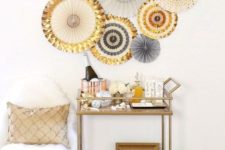 14 disco ball ornaments and shiny metallic paper fans over the cart is all you need for a festive touch