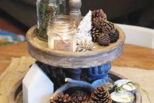 16 a wooden stand with pinecones, tinsel trees, candles and evergreens for a rustic feel
