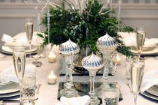 20 a chic silver-infused table setting with greenery and berries and silver imitating icicles and silver cutlery and chargers