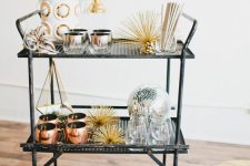 a bold NYE bar cart with gold stars, a disco ball and some succulents on top plus copper mugs