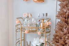a creative NYE bar cart with peachy disco ball lights, faux blooms, drinks and alcohol is a cool idea