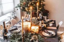 a fabulous holiday tablescape with graphite grey placemats, an evergreen runner, mercury glass candleholders, chic gold cutlery