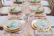 a lovely pastel wedding tablescape with a pink sequin tablecloth, gold-rimmed plates and mint grene napkins, gold-rimmed glasses