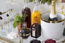 a stylish holiday bar with juices, alcohol, lights and fresh berris plus glasses to make a cool and savory drink