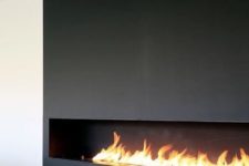 02 a long horizontal ethanol fireplace fully clad with black metal takes the whole wall and become a focal point here