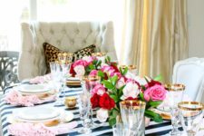 09 a colorful tablescape with a black and white tablecloth, gold touches and red and pink blooms