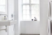 09 a white airy bathroom is accented with a terrazzo floor of grey, white and black