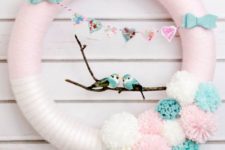 12 a pink wreath with a heart banner, bows, pompoms and a couple of lovebirds