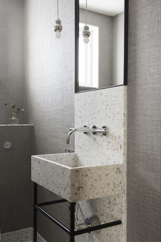 a white and grey terrazzo sink and a highlight along the wall