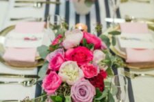 14 an elegant galentine tablescape with a striped runner, gold rim plates, pink napkins and bold pink florals