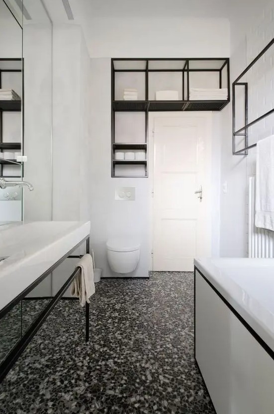 a bold contemporary bathroom in black and white, with a catchy terrazzo floor, black fixtures and framing is wow