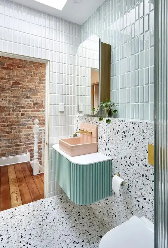 a bright bathroom with mint tiles, white terrazzo, a mint-colored vanity, a pink sink and a mirror cabinet