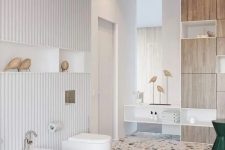 a creative bathroom with white walls and a bright terrazzo floor, white appliances and a plywood storage unit plus pendant lamps