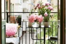 03 a tiny balcony with a small bench, a foldable chair and table plus pink blooms in pots