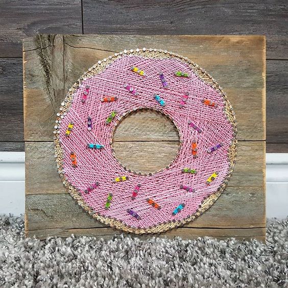 a fun and colorful pink donut string art with confetti decor
