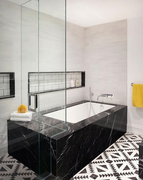 a bathtub placed into a black marble slab for a luxurious feel in the bathroom