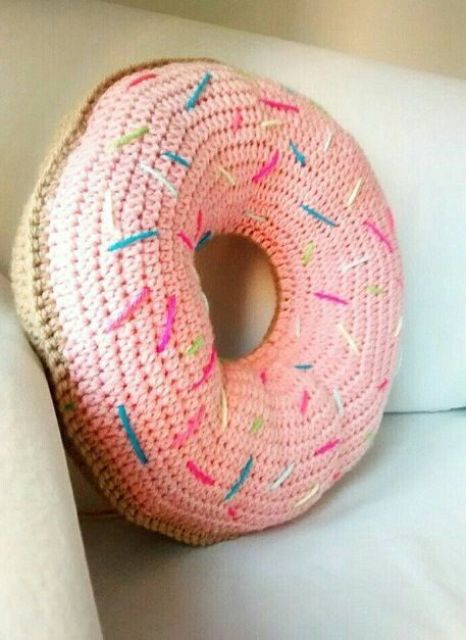 a crocheted confetti donut pillow with glazing