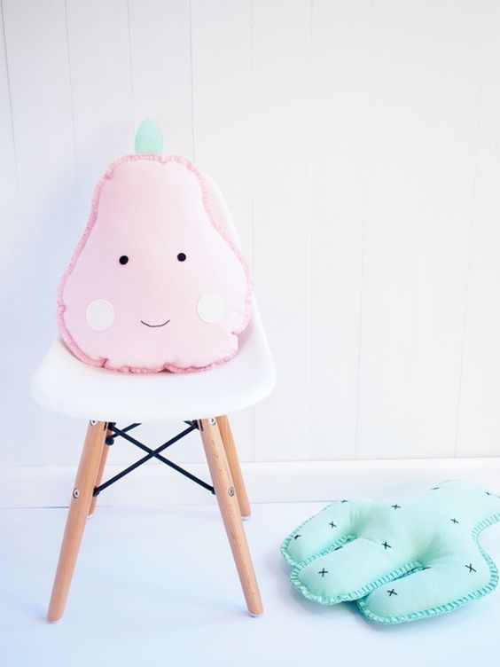 a pink pear cushion is delicate touch to a kid's space