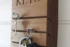 06 a wooden slab rack with some cutouts for inserting keys there is a cool and modern idea