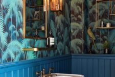blue wainscoting and green tropical leaf print wallpaper with brass touches for a glam tropical feel