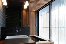 07 a modern bathroom clad with wood and black tiles for an edgy look