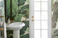 09 bold tropical leaf wallpaper covering the whole space for a glam and bold bathroom