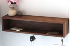 10 a modern wooden box shelf provides storage for various small stuff and some hooks for keys